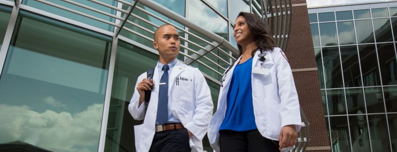 two medical students walking and talking outside the Virginia Tech-Carilion facility