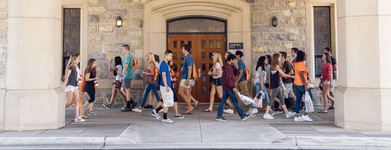 students of many ethnicities walking on campus near Torgersen Hall bridge